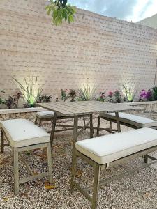 una mesa de picnic, 2 sillas y una pared de ladrillo en Casa Nardo Planta Alta, en Valladolid