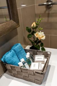 um lavatório de casa de banho com uma cesta de toalhas e uma flor em Lustica Apartments Marina em Tivat