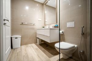 uma casa de banho com um WC, um lavatório e um espelho. em Lustica Apartments Marina em Tivat