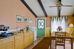 a kitchen with a table and a green door at Americas Best Value Inn Arkansas City in Arkansas City