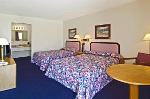 a hotel room with two beds and a table at Americas Best Value Inn Arkansas City in Arkansas City +20 photos