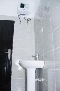 a bathroom with a sink and a camera on the wall at Jama Residence in Abuja