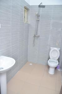 a bathroom with a toilet and a sink at Jama Residence in Abuja