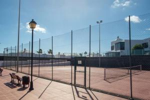 a tennis court with a fence and a basketball hoop at Casa Paula, Costa Teguise in Costa Teguise