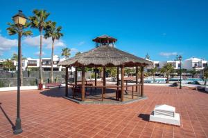 a pavilion with a table and a straw roof at Casa Paula, Costa Teguise in Costa Teguise