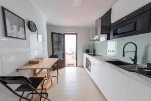 a kitchen with a wooden table and a counter top at Casa Paula, Costa Teguise in Costa Teguise