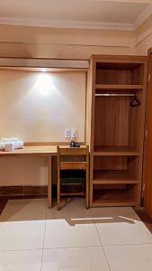 a room with a desk and a closet at Hotel Lux in Poços de Caldas