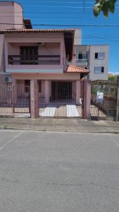 una casa con una valla al lado de la calle en Casa 4 Quartos 300m do Mar,Casa Rosada, en Florianópolis