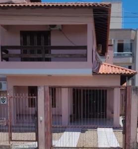 una casa con una puerta delante de ella en Casa 4 Quartos 300m do Mar,Casa Rosada, en Florianópolis