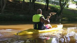 un hombre en un kayak en el agua tocando una guitarra en Parque Hotel Pimonte, 