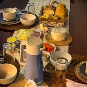 una mesa con platos de comida y una jarra en ella en Café com Morada - Cama e Café en Jundiaí