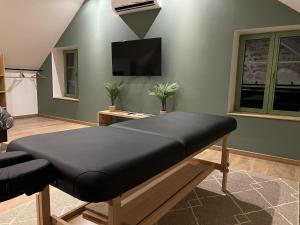 sala de estar con cama y TV de pantalla plana en Appart Spa Privatif Laon, en Laon