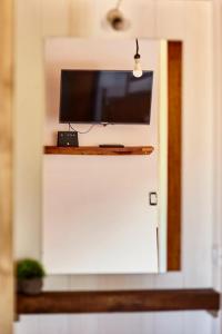 a flat screen tv on a wall above a door at Aves del Paraiso 1 in Punta Del Diablo