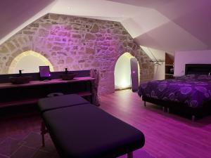 a bedroom with two beds and a stone wall at Appart Spa Privatif Laon in Laon