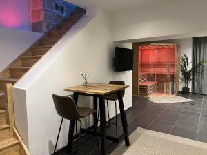 a dining room with a table and a staircase at Appart Spa Privatif Laon in Laon