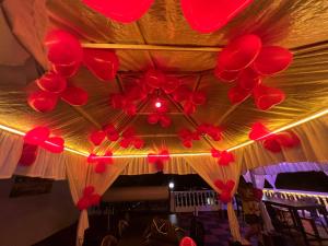 a bunch of red balloons hanging from a ceiling at Baga Beach Myron in Baga