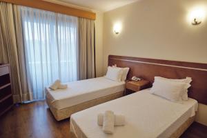 a hotel room with two beds and a window at Hotel O Guerreiro in Ponte da Barca
