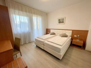 a bedroom with a large white bed and a window at Hotel Garden Arco in Arco