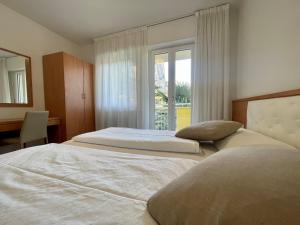 two beds in a bedroom with a window at Hotel Garden Arco in Arco