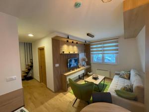 a living room with a couch and a table at Vila Jahor Superior Apartman 16 “Minja” in Jahorina