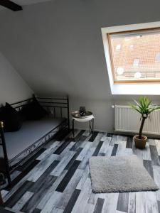 1 dormitorio con cama, ventana y alfombra en Schönes Messe-Ferien Apartment mit vielen Extras en Bröckel