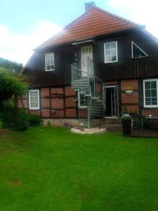 una casa con un patio de hierba delante de ella en Schönes Messe-Ferien Apartment mit vielen Extras en Bröckel