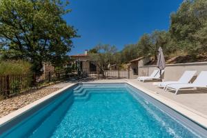 einen Pool mit zwei Liegestühlen und ein Haus in der Unterkunft Le charme d'un pigeonnier provençal avec piscine in Oraison