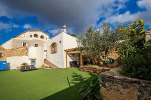 Bisbal del PenedèsにあるCatalunya Casas Captivating Villa in the Vineyard close to Sitgesの緑の芝生のある家の外観