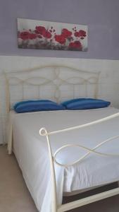 1 dormitorio con cama blanca y almohadas azules en Villino Celeste fronte spiaggia, en Torre Lapillo