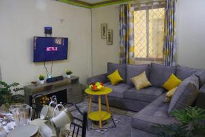 sala de estar con sofá y TV en Stylish Cozy Home, en Mombasa