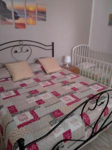 Appartamento con giardino في لامبيدوسا: غرفة نوم عليها سرير ولحاف