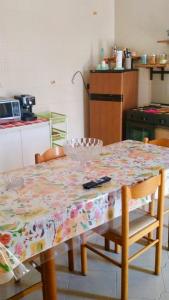 une table avec un tissu de table fleuri dans la cuisine dans l'établissement Appartamento con giardino, à Lampedusa