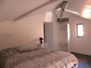 sypialnia z łóżkiem w białym pokoju w obiekcie gîte du puits w mieście Laives