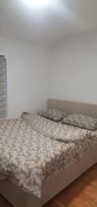 a bed in a bedroom with a white wall at Happy Place in Novi Grad