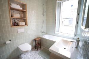 ein Badezimmer mit einer Badewanne, einem WC und einem Waschbecken in der Unterkunft Villa Jeanne - Confort et plage in Le Tréport