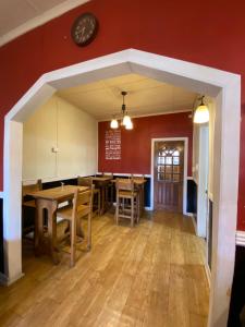 a dining room with wooden tables and a red wall at Kawi Hotel in Puerto Natales +28 photos