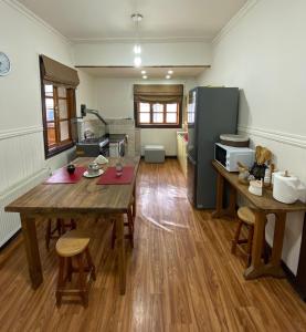 a kitchen with a wooden table and a refrigerator at Kawi Hostel in Puerto Natales