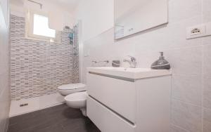 a white bathroom with a toilet and a sink at Casa D'Amore con Piscina Privata in Alessano