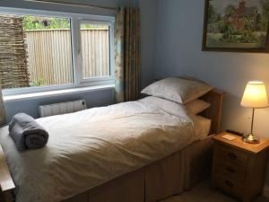 a bedroom with a large bed with a window at Beautifully appointed & cosy self contained annexe 