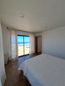 una camera con letto e vista sull'oceano di Casa MORENA by Alto Curanipe a Pelluhue