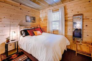 1 dormitorio con paredes de madera y 1 cama con TV en Idyllic Finns Retreat - Walk to Lake Huron, en Oscoda