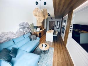 a living room with a blue couch and a table at Apartament N&B in Szklarska Poręba