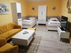 - un salon avec deux lits et un canapé dans l'établissement Apartmán West, à Poprad