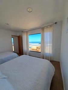 una camera con due letti e vista sull'oceano di Casa MORENA by Alto Curanipe a Pelluhue