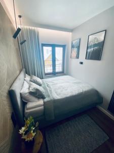 niewielka sypialnia z łóżkiem i oknem w obiekcie Apartament N&B w Szklarskiej Porębie