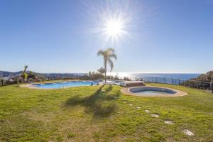 una piscina en un campo con el océano al fondo en Casa Segerlund, en Almuñécar