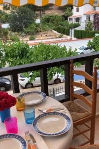 a table with plates and utensils on a balcony at Playa Las Fuentes Bello LUXURY Apartament Pp2 PET in Alcossebre