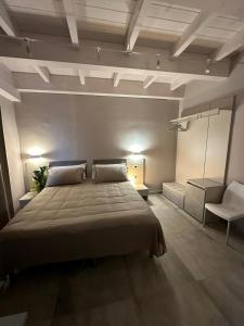 um quarto com uma cama grande e uma cadeira em Volsci Rooms em Sora