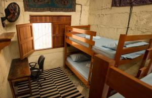 a room with two bunk beds and a desk and a window at Estación Biológica Agualí in Matagalpa