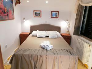 a bedroom with a bed with two towels on it at Apartments Villa Vera in Novi Vinodolski